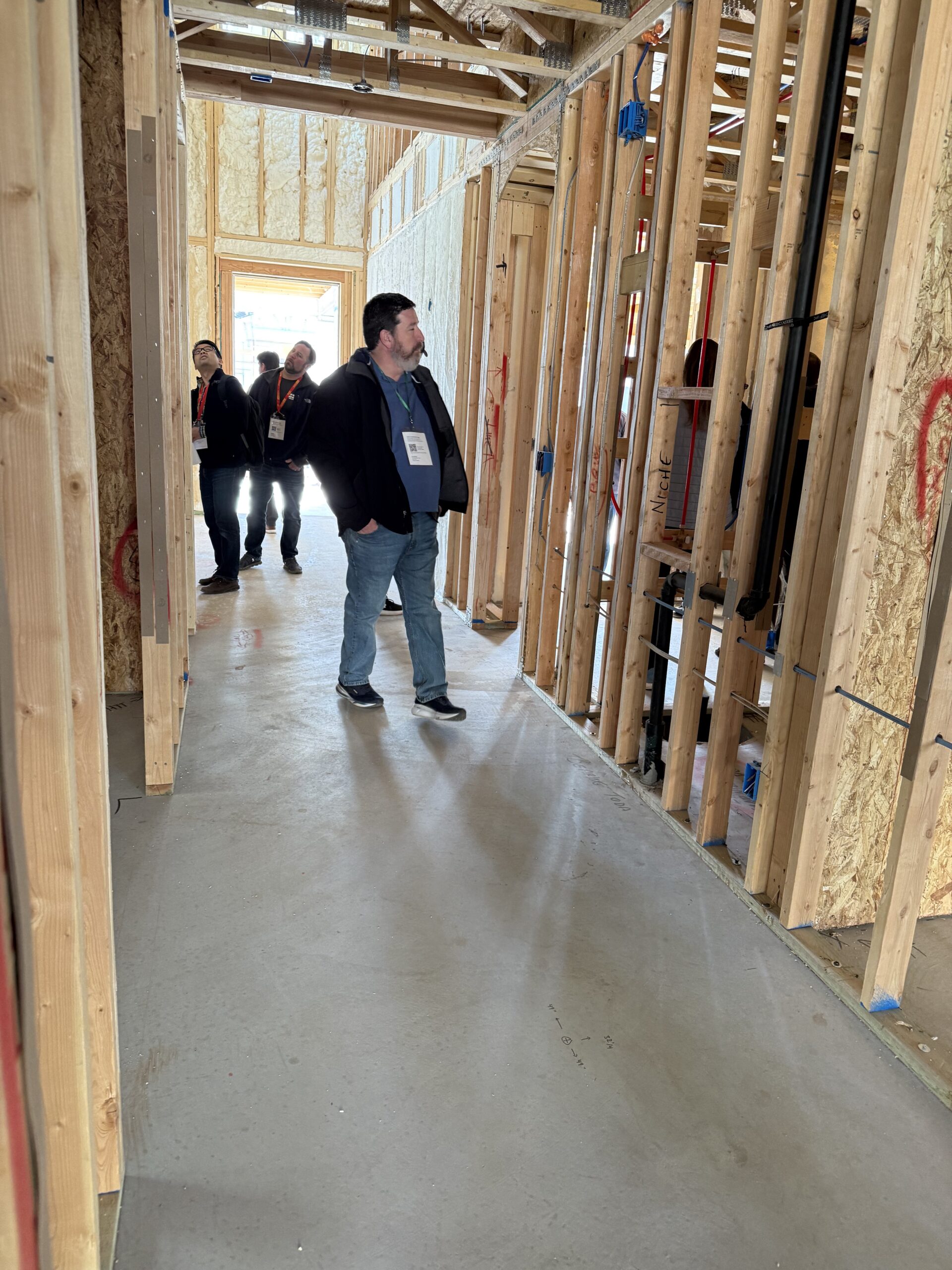 Man walking through new  home in framing stage